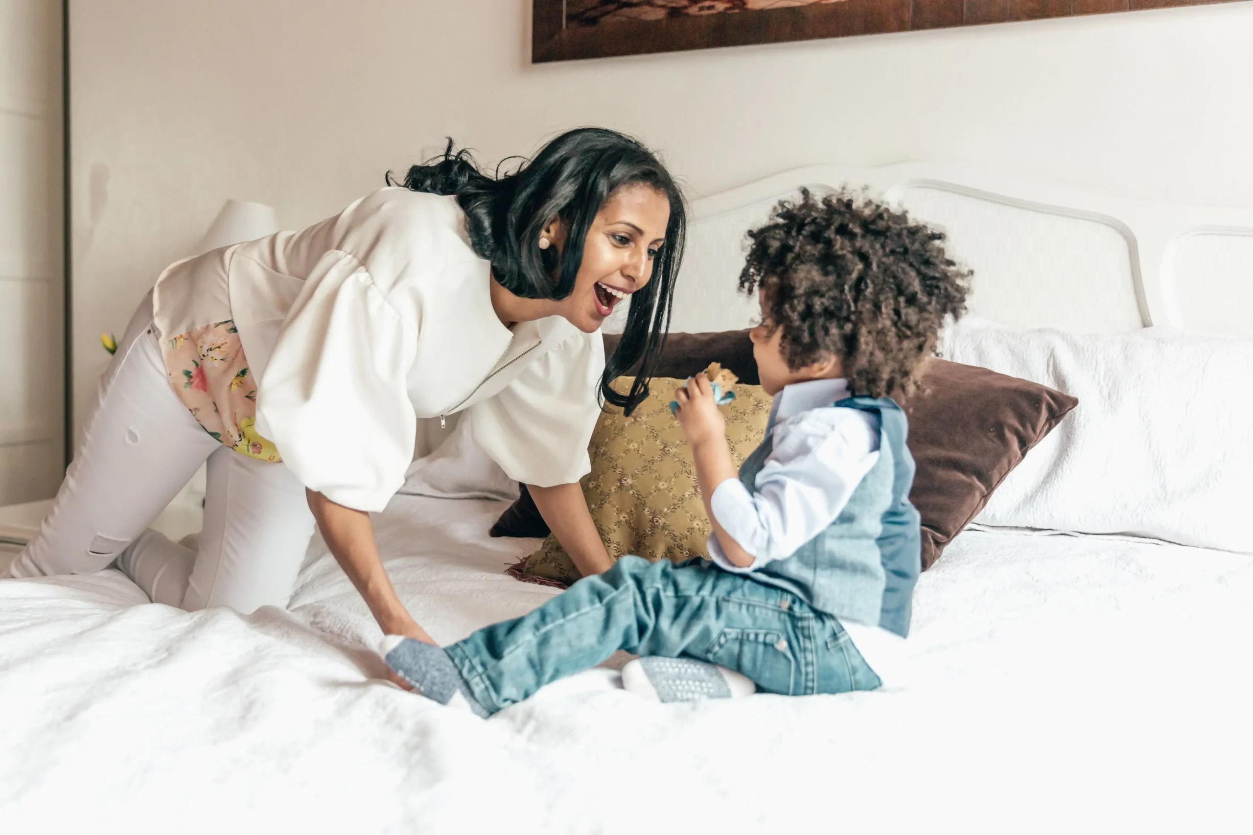 Mother Playing With Son In Bedroom